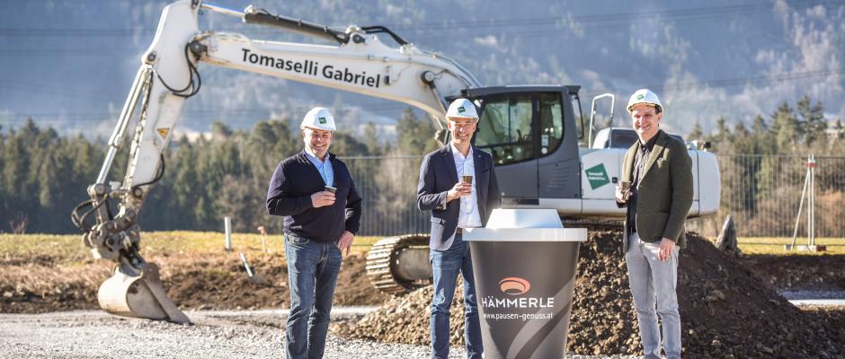 Martin Konzet, Bürgermeister von Bludesch; Markus Hämmerle, Geschäftsführer von Hämmerle Kaffee und Philipp Tomaselli, Geschäftsführer von Tomaselli Gabriel Bau, freuen sich über den Baubeginn und genießen dabei einen Becher Hämmerle-Kaffee.