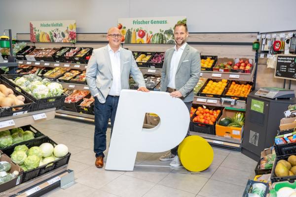 Kai Pataky (rechts) und Niko Karras (links) mit dem neuen PENNY Logo