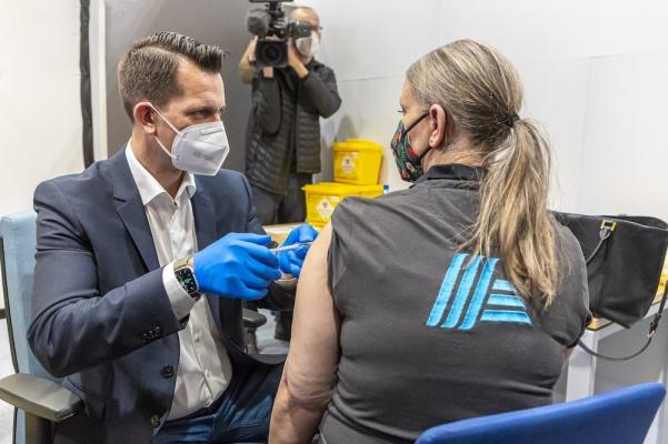 Minister Wolfgang Mücksten impft eine Mitarbeiterin der Hofer KG