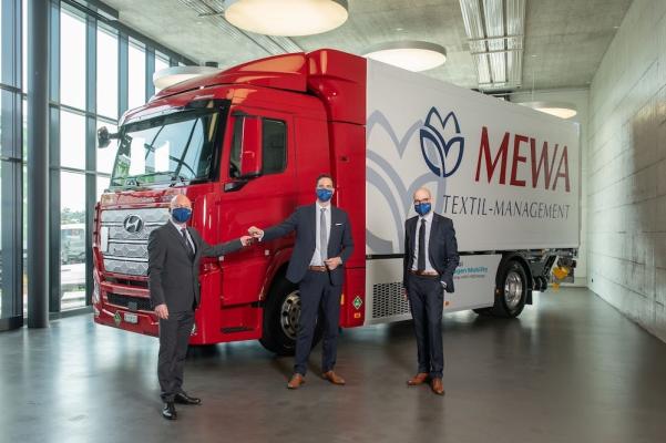George Lazar, MEWA Schweiz, Mark Freymüller, Hyundai HM. Kay Simon, MEWA Wiesbaden, übernehmen den Hyundai Xcient Fuel Cell Wasserstoff-Lkw (v.l.n.r.) 